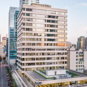 Exterior view of 116 Alberni Street, highlighting a white, multi-story office building. 