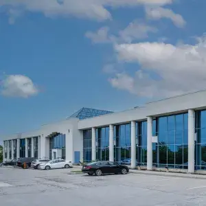 two storey suburban office building with grey brick and blue tinted windows