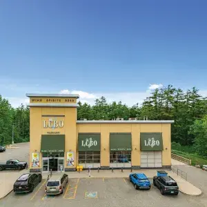 Front of standalone LCBO building with yellow brick and green awning