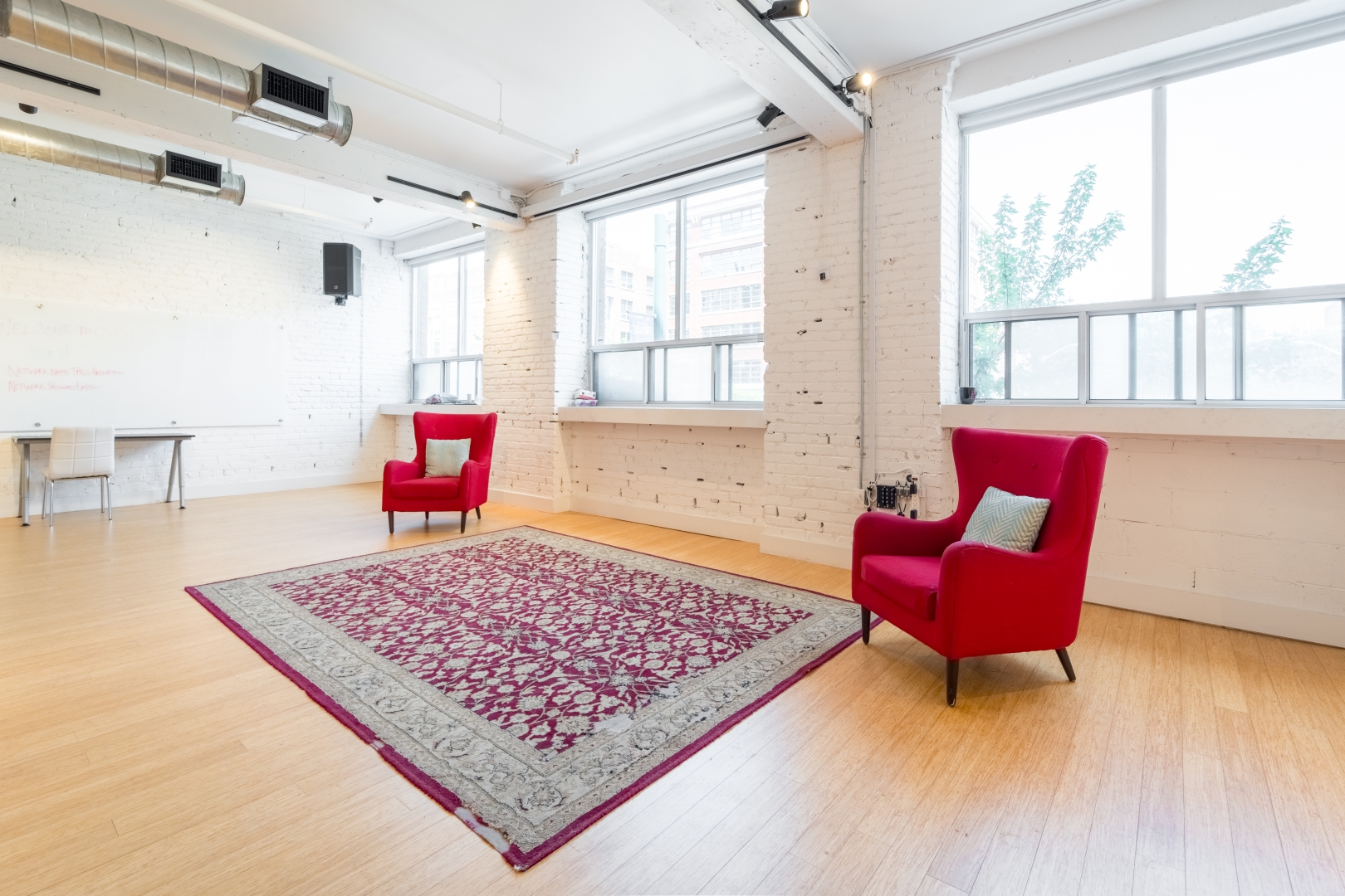 192 Spadina Avenue Third Floor event space with large carpet and red chairs