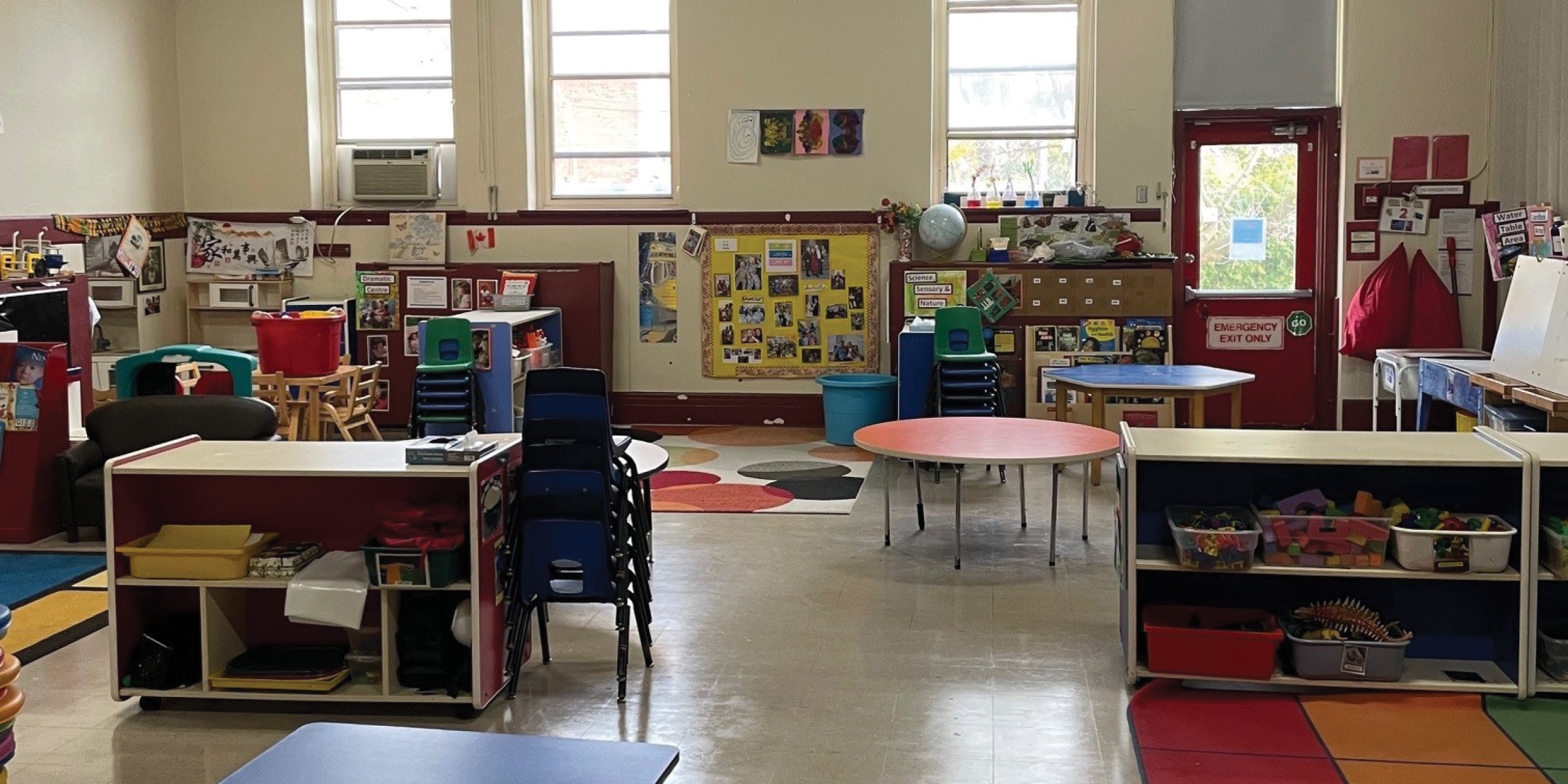 611 St. Clair Avenue W interior view of classroom with large window, tables and chairs 