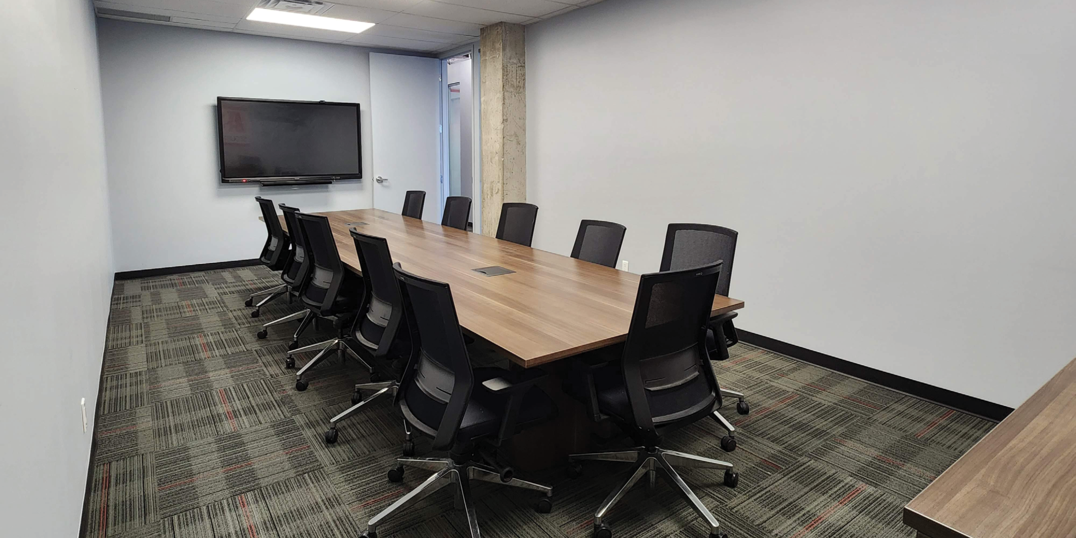 200 Consumers Road Boardroom with a TV overlooking the desk and chairs