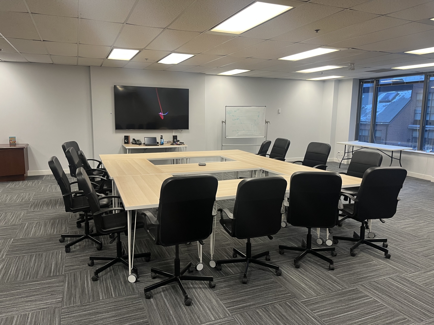 184 Front Street E boardroom with a TV overlooking the desk and chairs