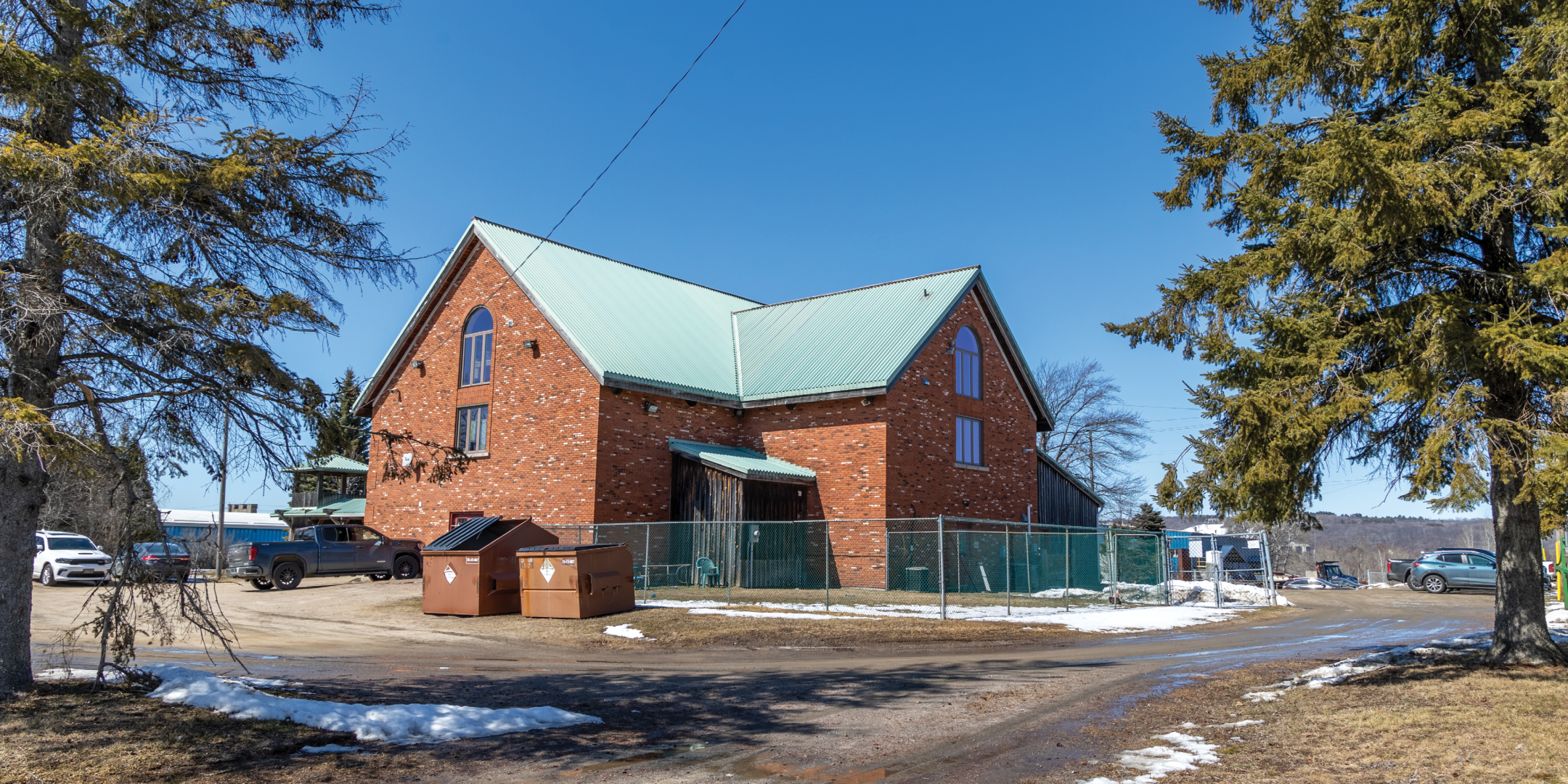 Side of Red Brick Farmhouse with fenced in yard