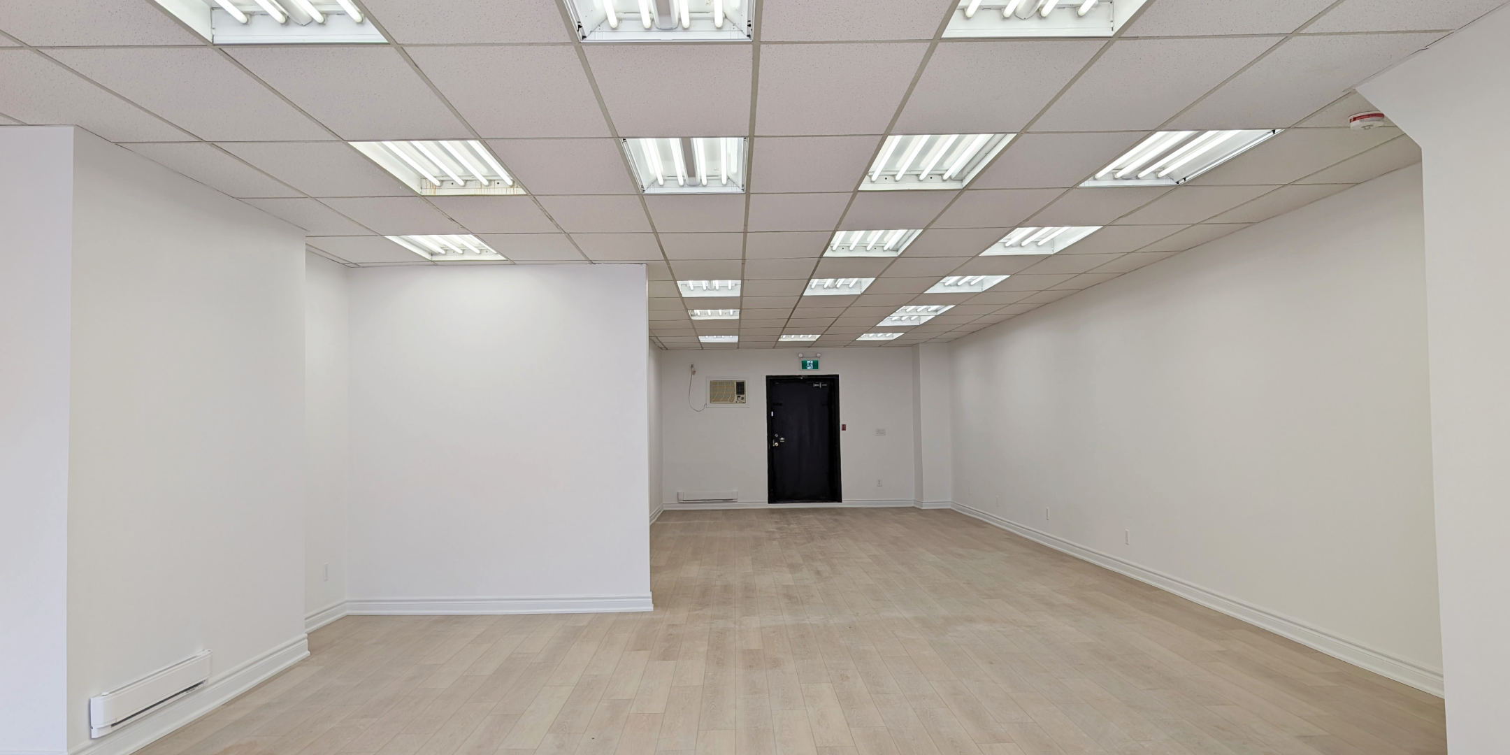 1710 St. Clair Avenue W Interior Facing inward towards retail open space with hardwood floors and white walls