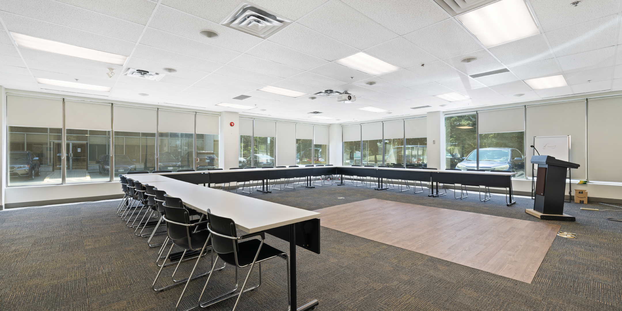 open space area set up with u shaped boardroom table with glass and natural light