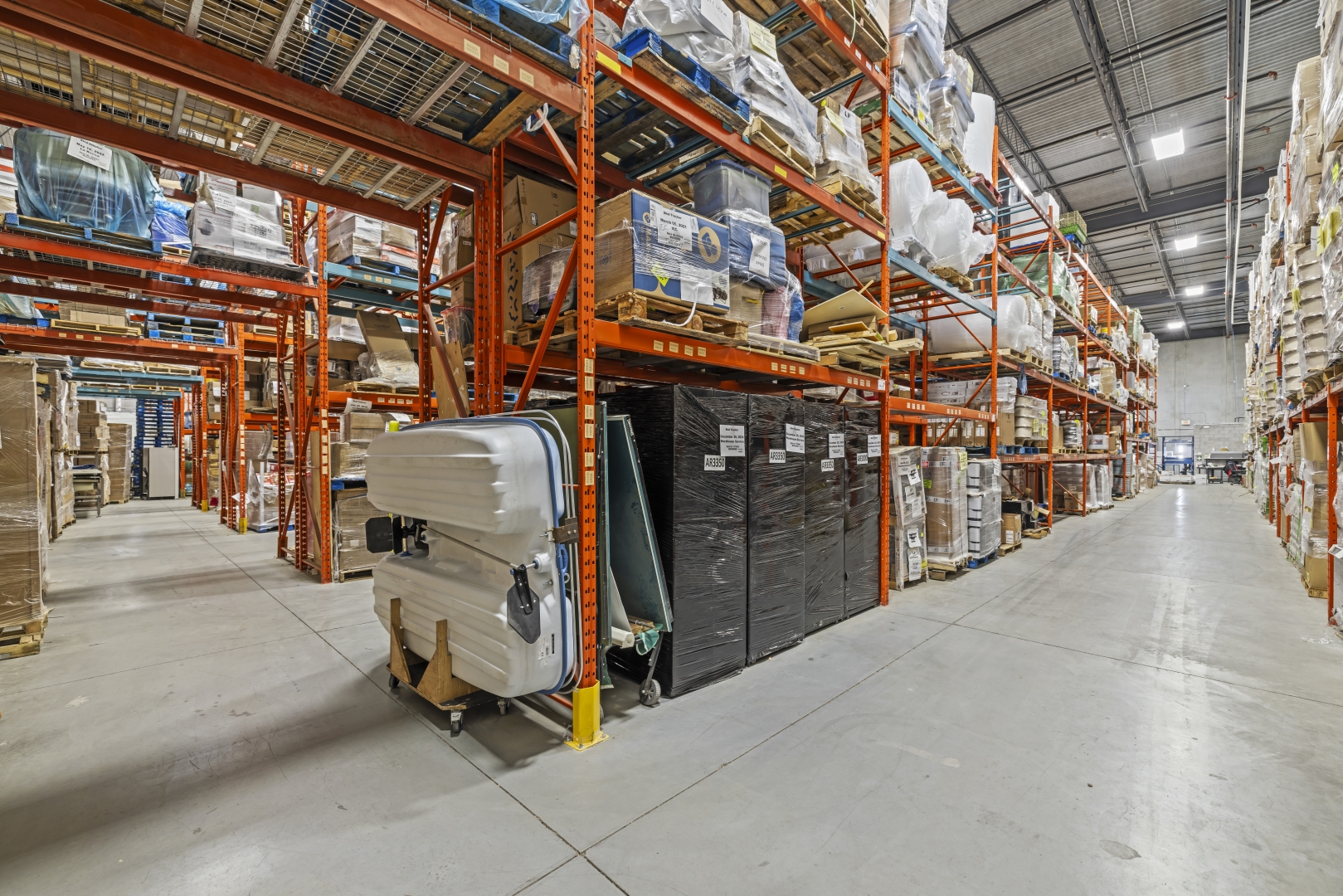 30 Via Renzo Drive interior warehouse with concrete floors and rows of shelving to the ceiling 