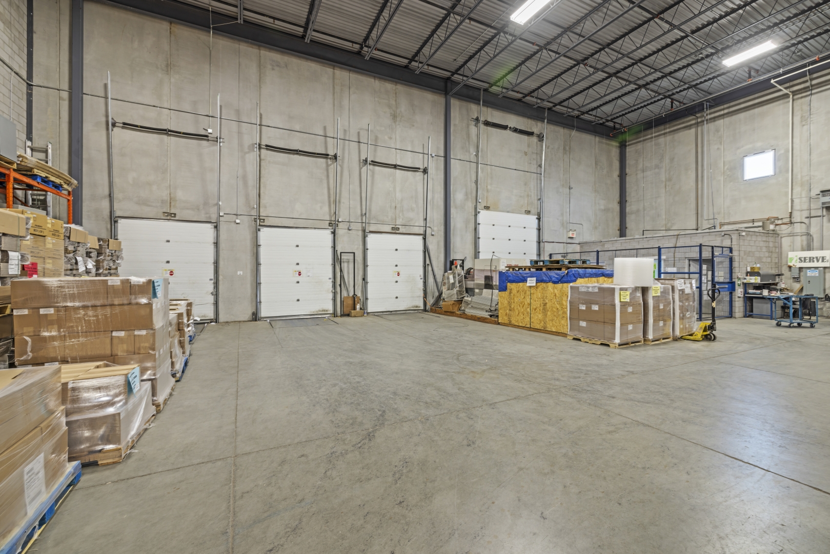 30 Via Renzo Drive interior warehouse with concrete floors and three truck level shipping doors and one drive in door 