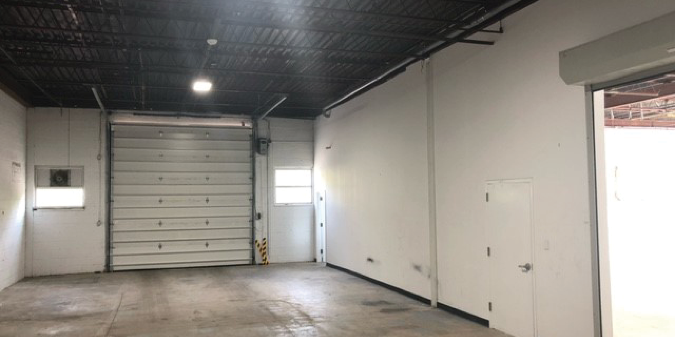 55 Gervais Drive Industrial Area with concrete floors and white walls and shipping door