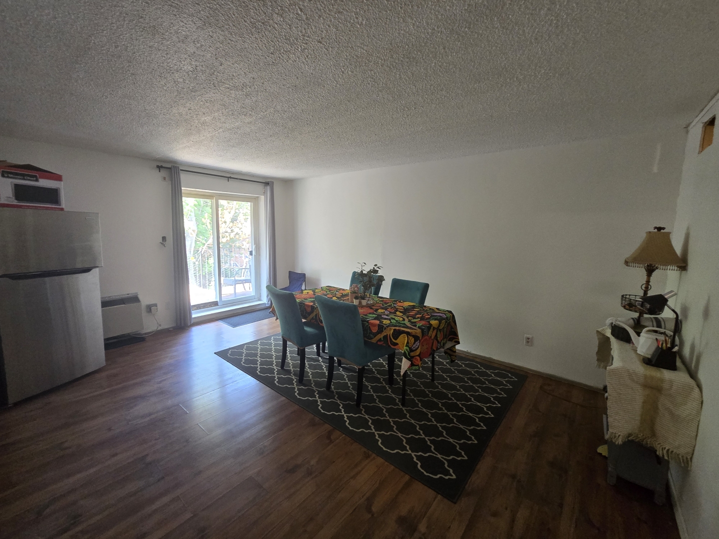 58-60 Kensington Avenue Unit 204 dining room with table and chairs and a fridge beside the window