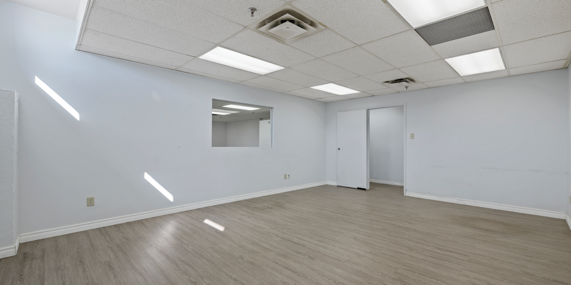 3636 Weston Road office with white walls, light wood floors, and suspended ceiling