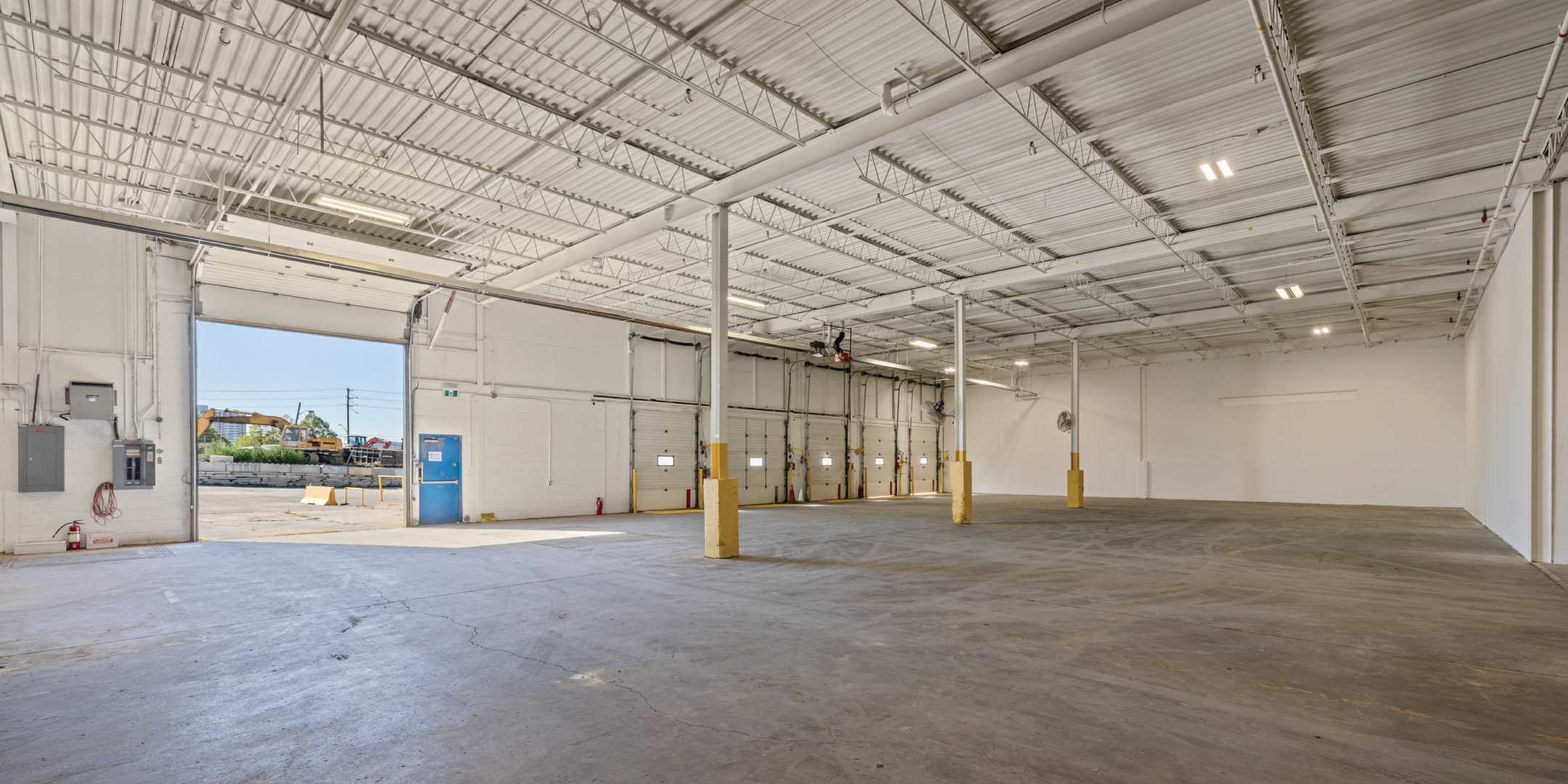 3636 Weston Road interior warehouse with one drive in shipping door open to the outside and four closed truck level shipping doors 