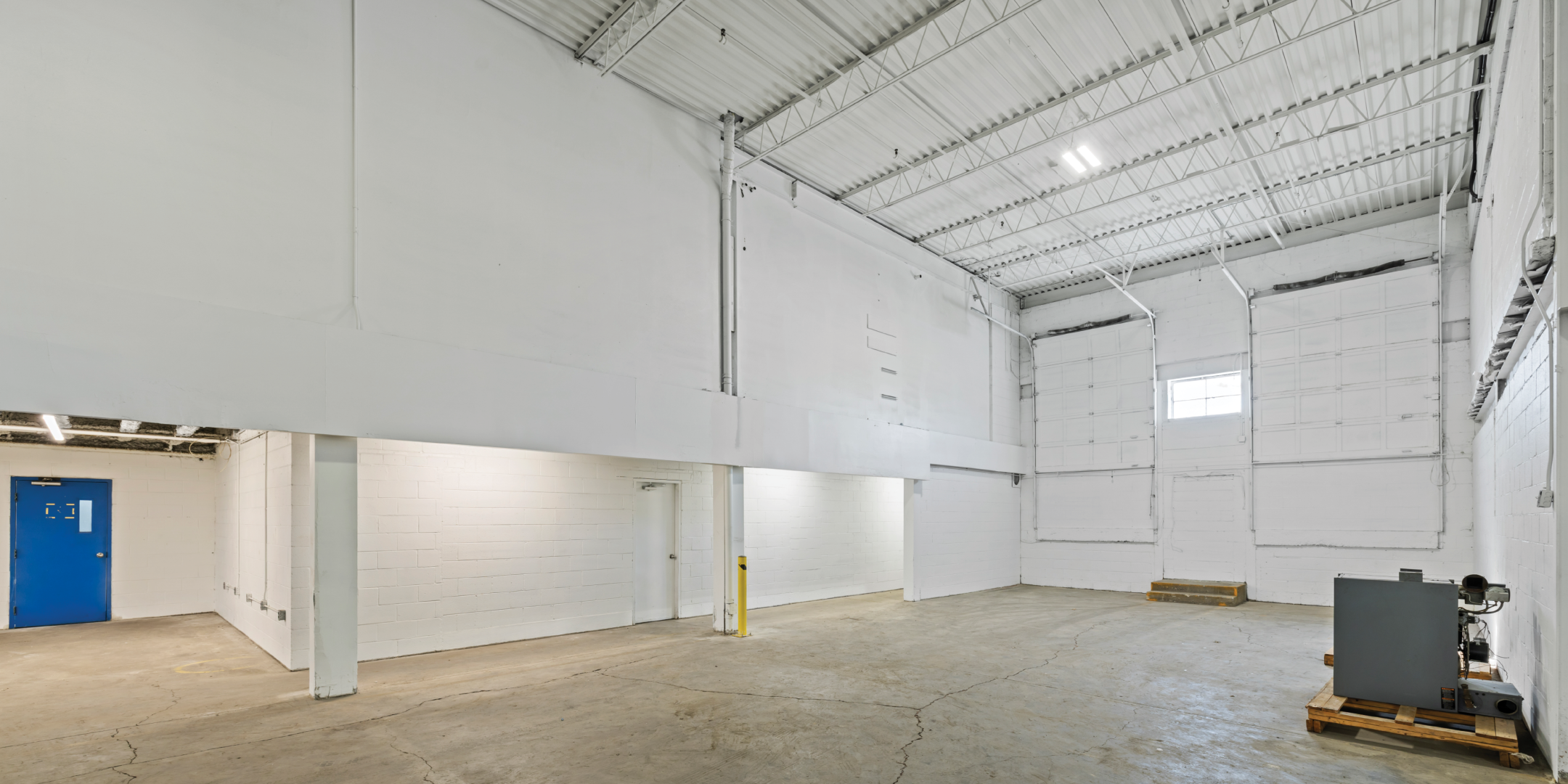 3636 Weston Road interior empty warehouse with concrete floors and white walls and one window on far wall 