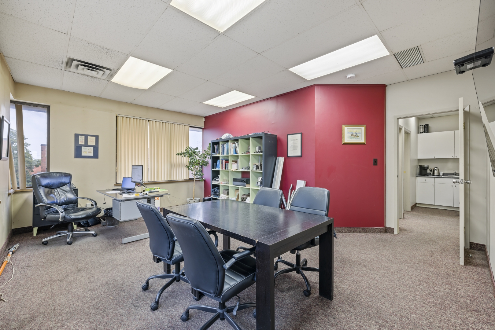 7669 Kimbel Street office with carpet floors, windows, and a board room table and chairs in the middle