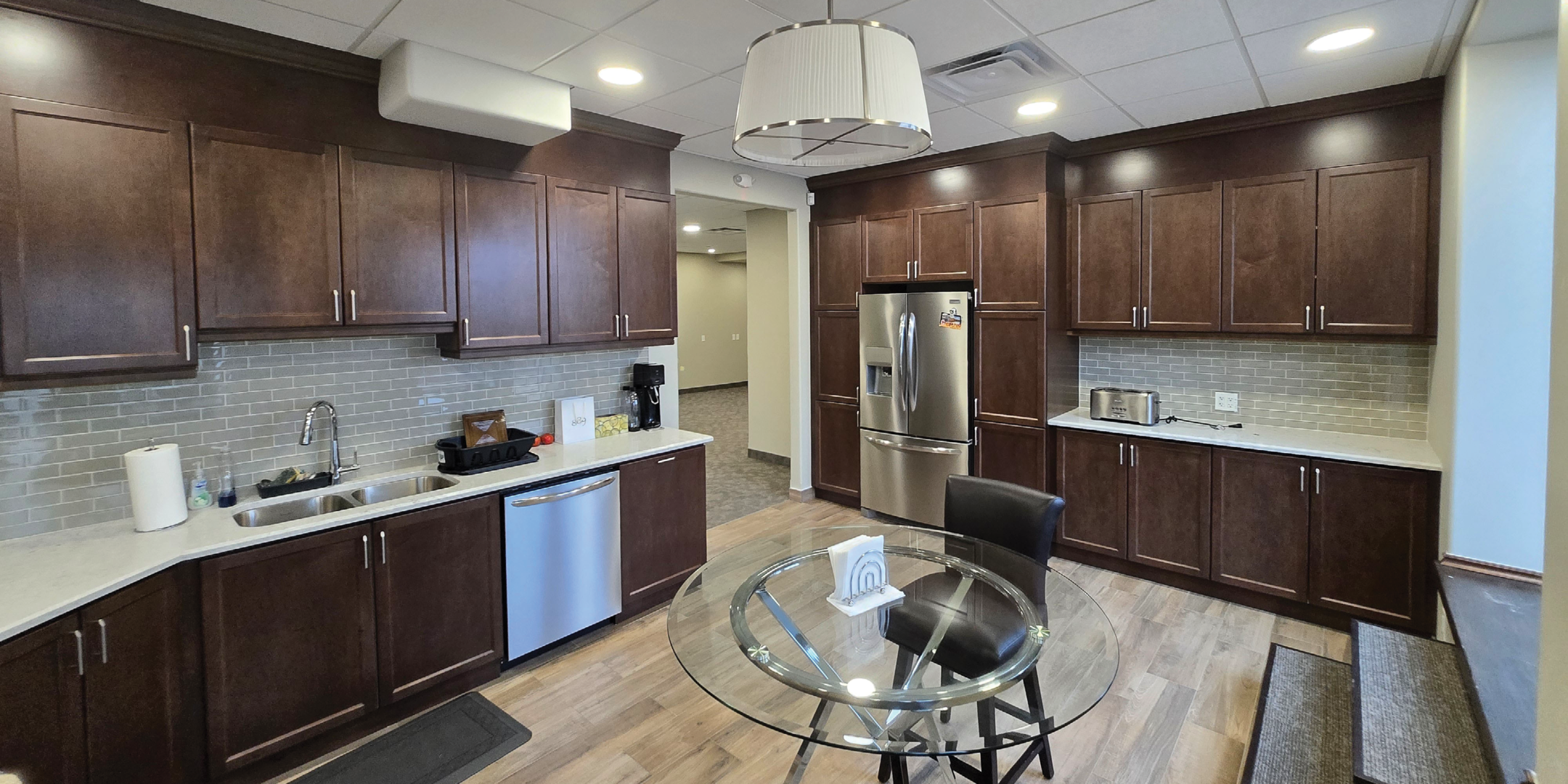200 Cachet Woods Court Kitchenette with brown cabinets, fridge, sink, dishwasher, table and chairs