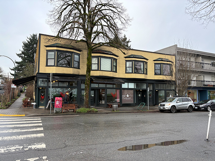 2 storey mixed use commercial and residential building with yellow siding and grey accents