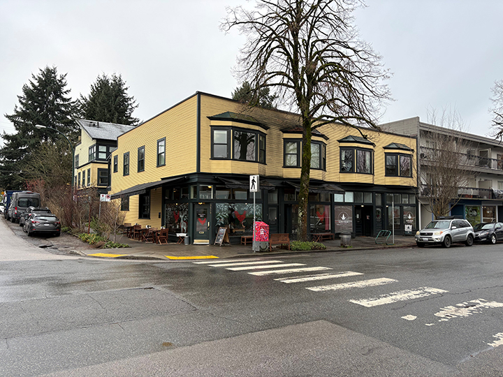 2 storey mixed use commercial and residential building with yellow siding and grey accents