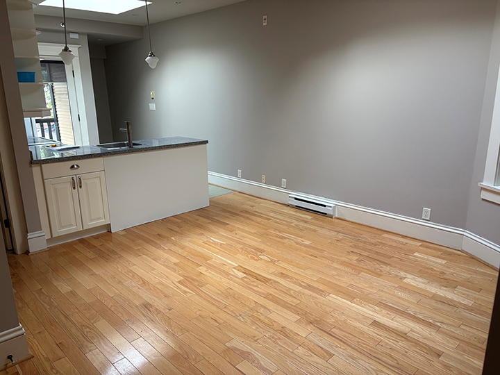 empty kitchen/dining open area with light hardwood flooring and grey walls