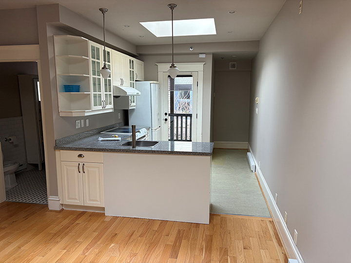kitchen area with prep area and sink, light hardwood flooring and grey walls