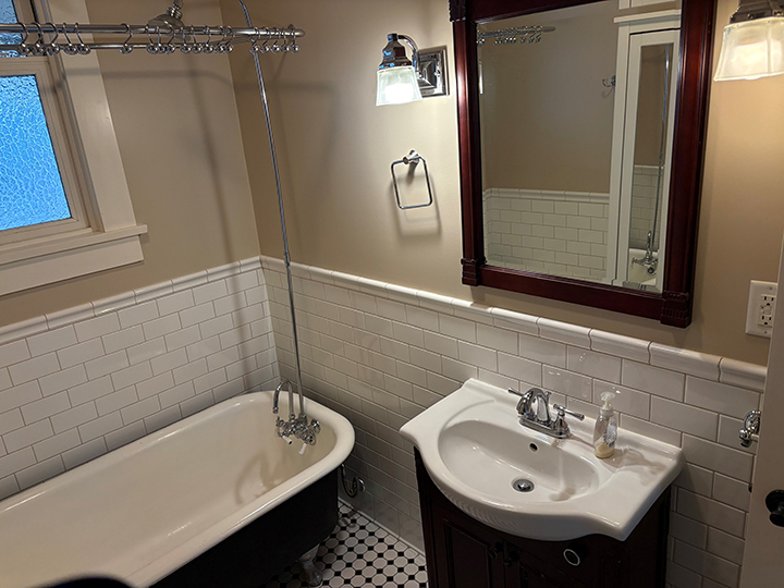 bathroom with checkered tile flooring, sing and bathtub