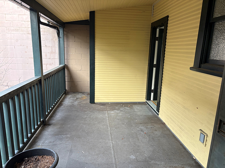 balcony with yellow siding and grey wood accents