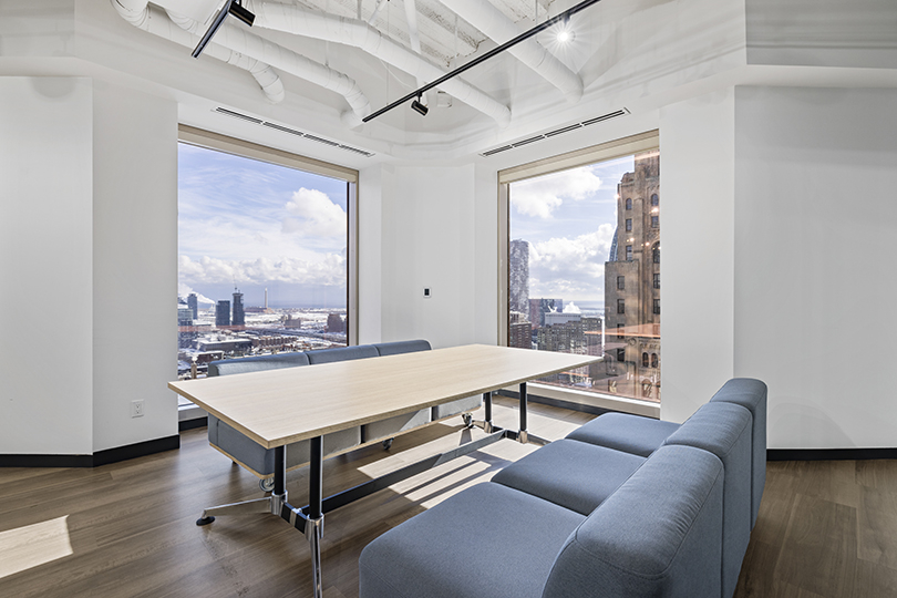 40 King St W interior view of relaxing area with large windows and blue couch