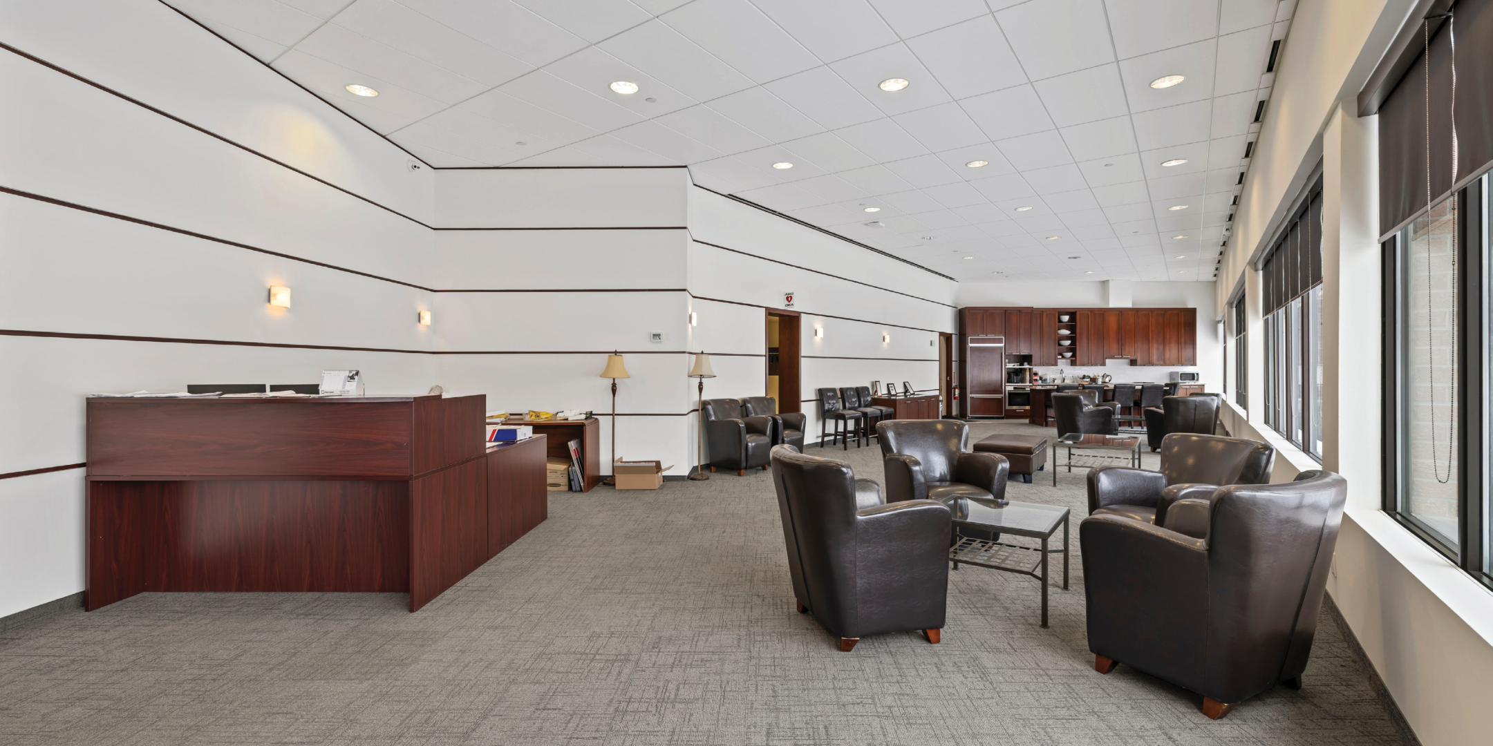 reception and waiting area with white panelled walls and dark coloured furniture