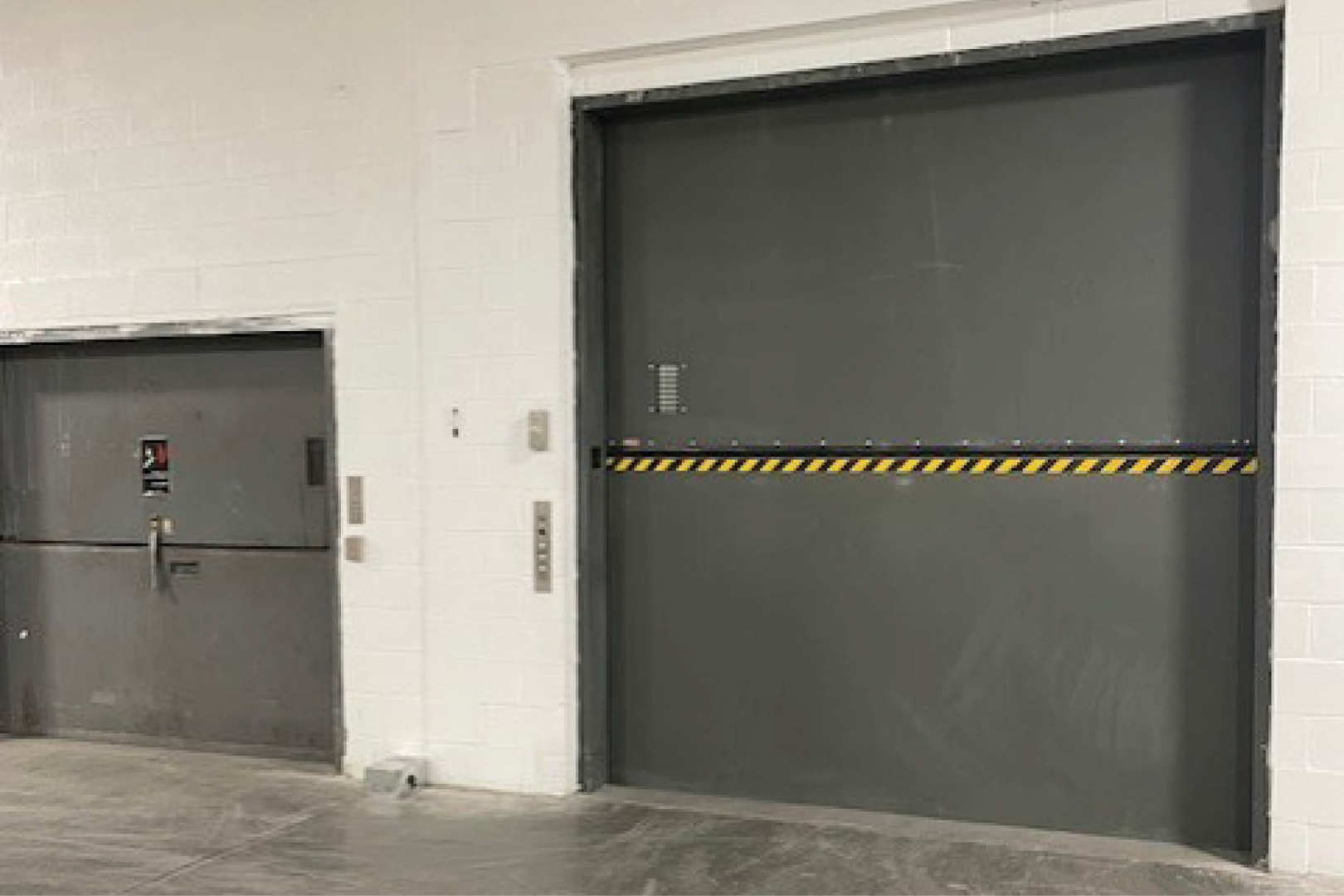 36 Horner Avenue a large freight elevator and service door inside a warehouse space.