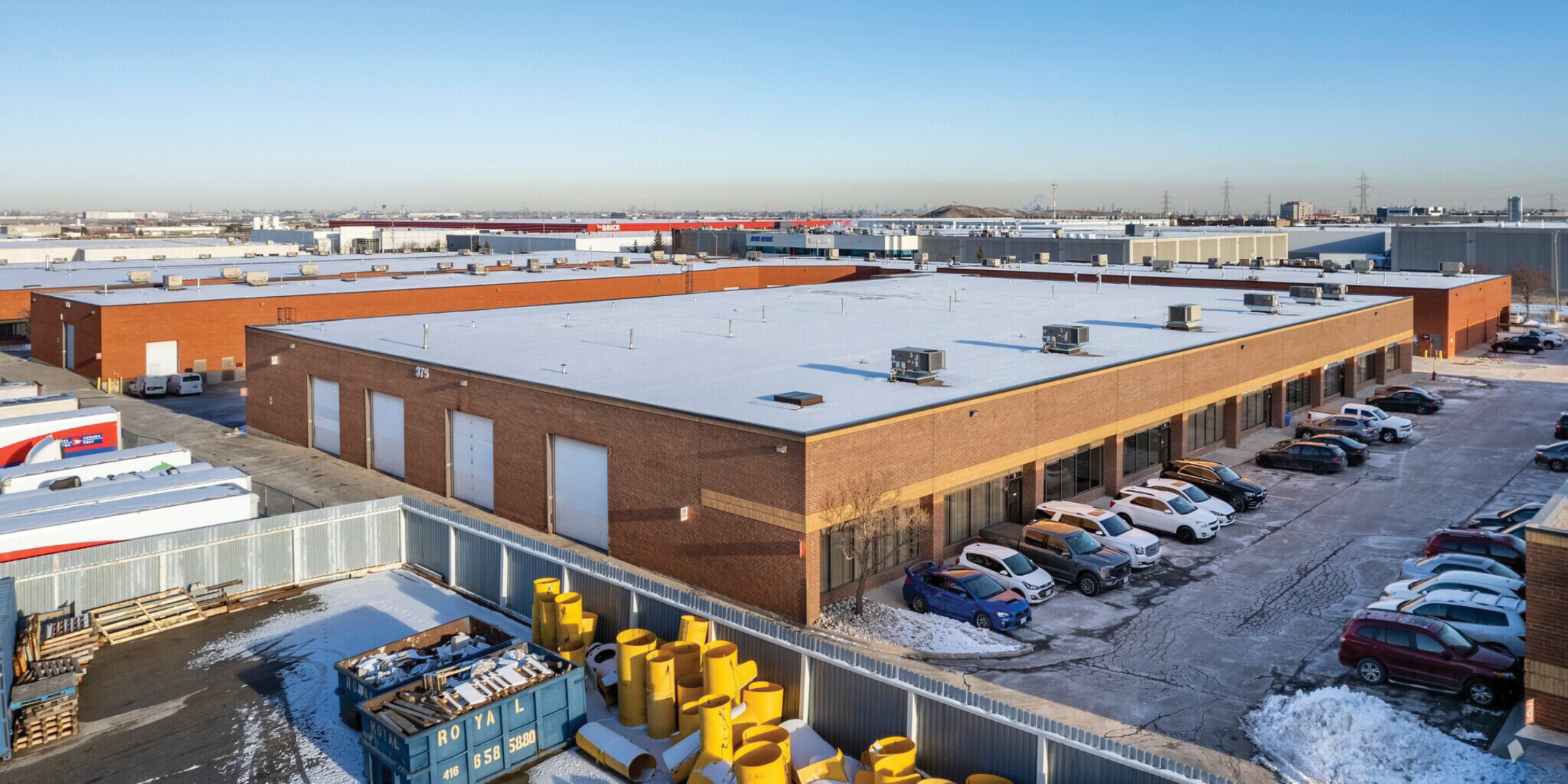 375 Admiral Boulevard building exterior showing back of the building, loading door, and parking