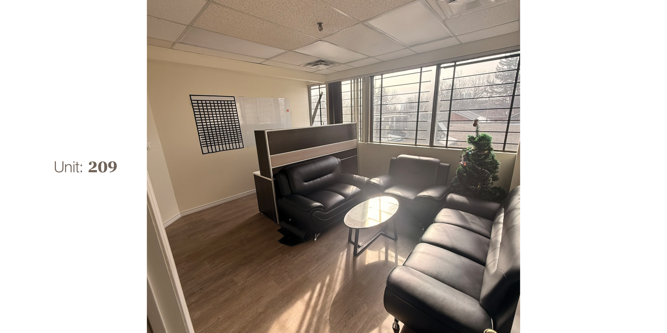 4433 Sheppard Avenue E Unit 209 Office Area with large windows, table, chairs and sofa