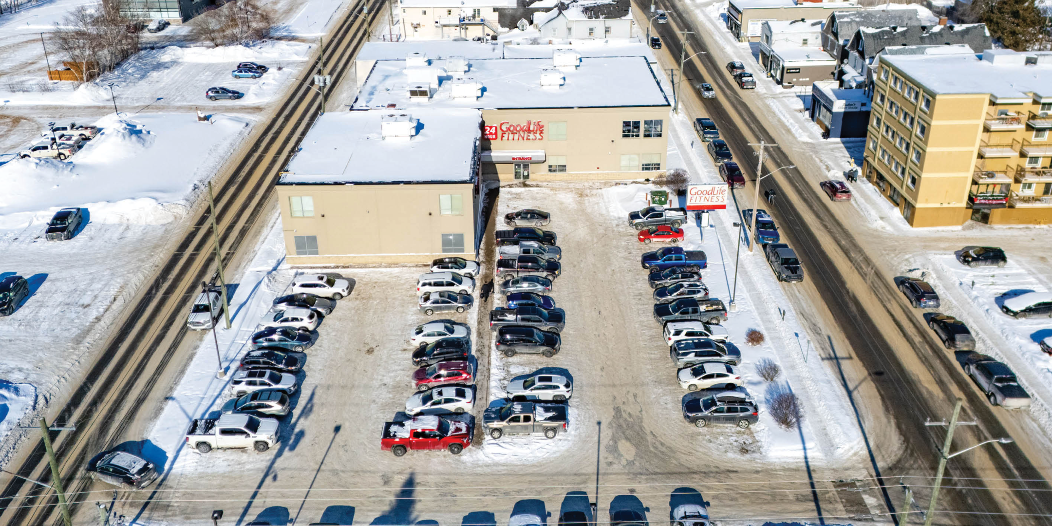 Aerial of Good Life Fitness Building and Parking lot with lots of vehicles in parking lot