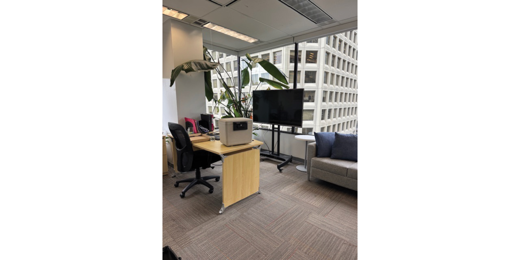 Interior of 116 Alberni Street showing a office space with a desk, black chair, and a small printer.