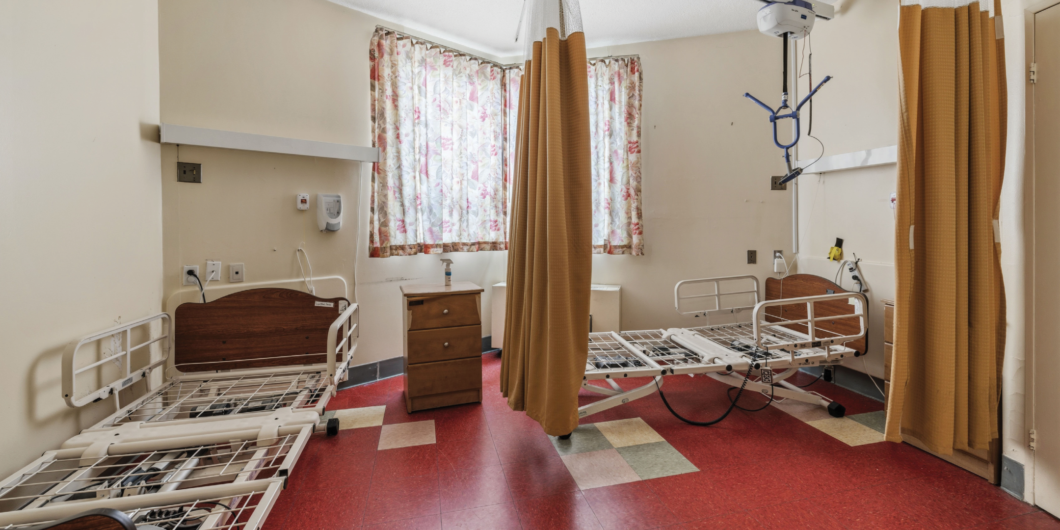 1195 Queen Street E patient room with beds and privacy curtains.