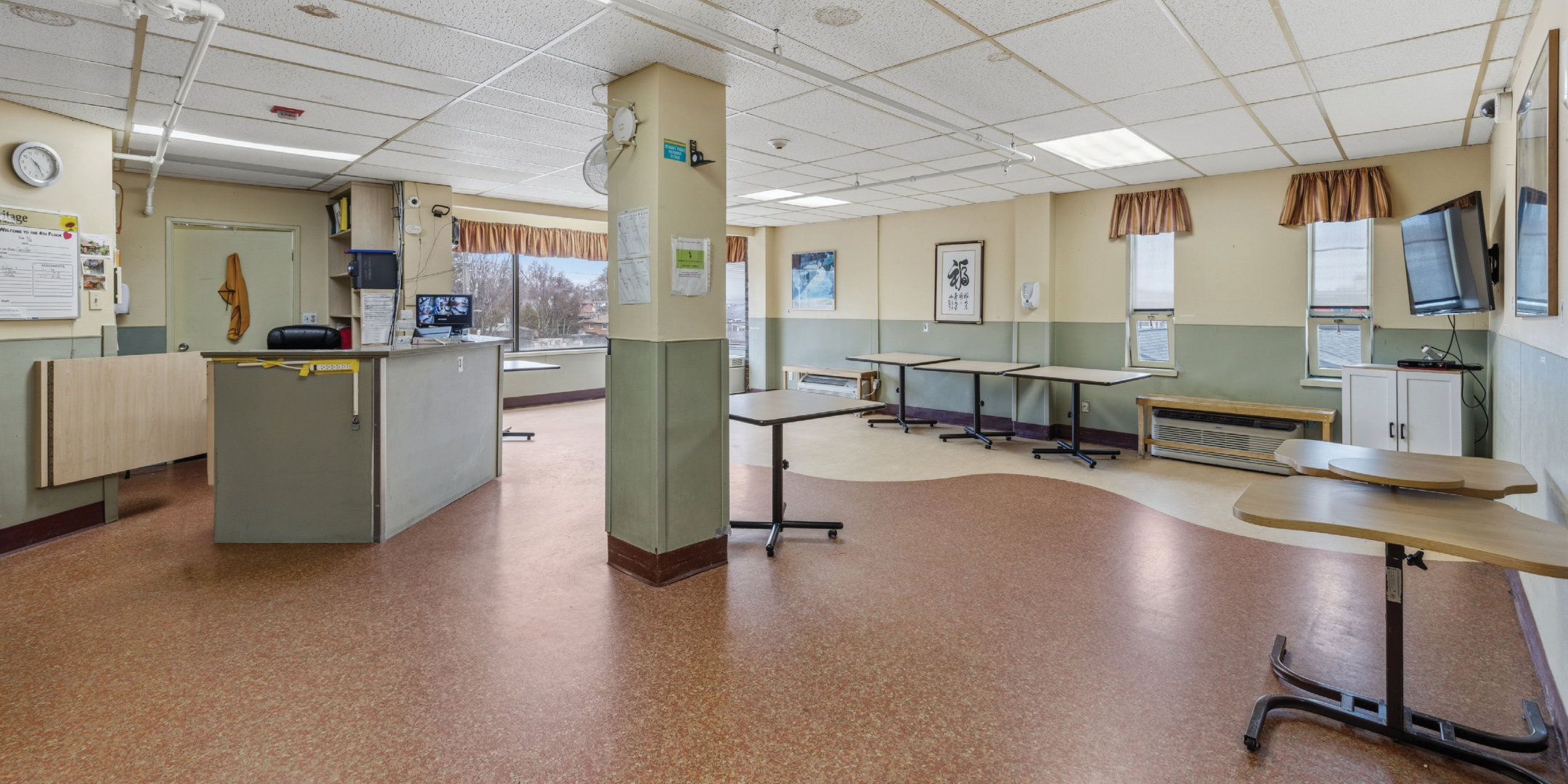 1195 Queen Street E Common room with tables and reception desk