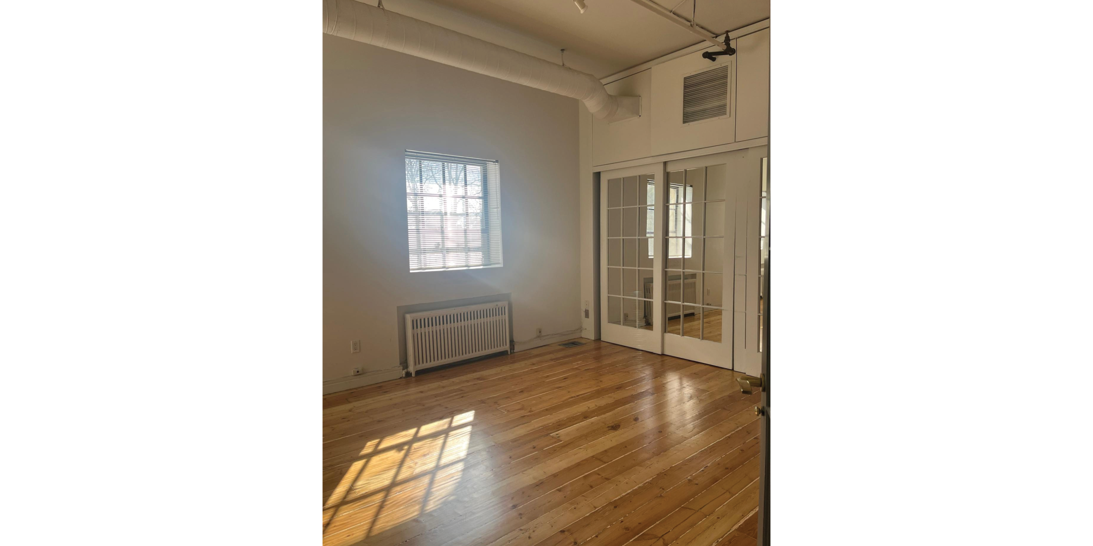225 Macpherson Avenue features a bright room with hardwood floors and glass doors.
