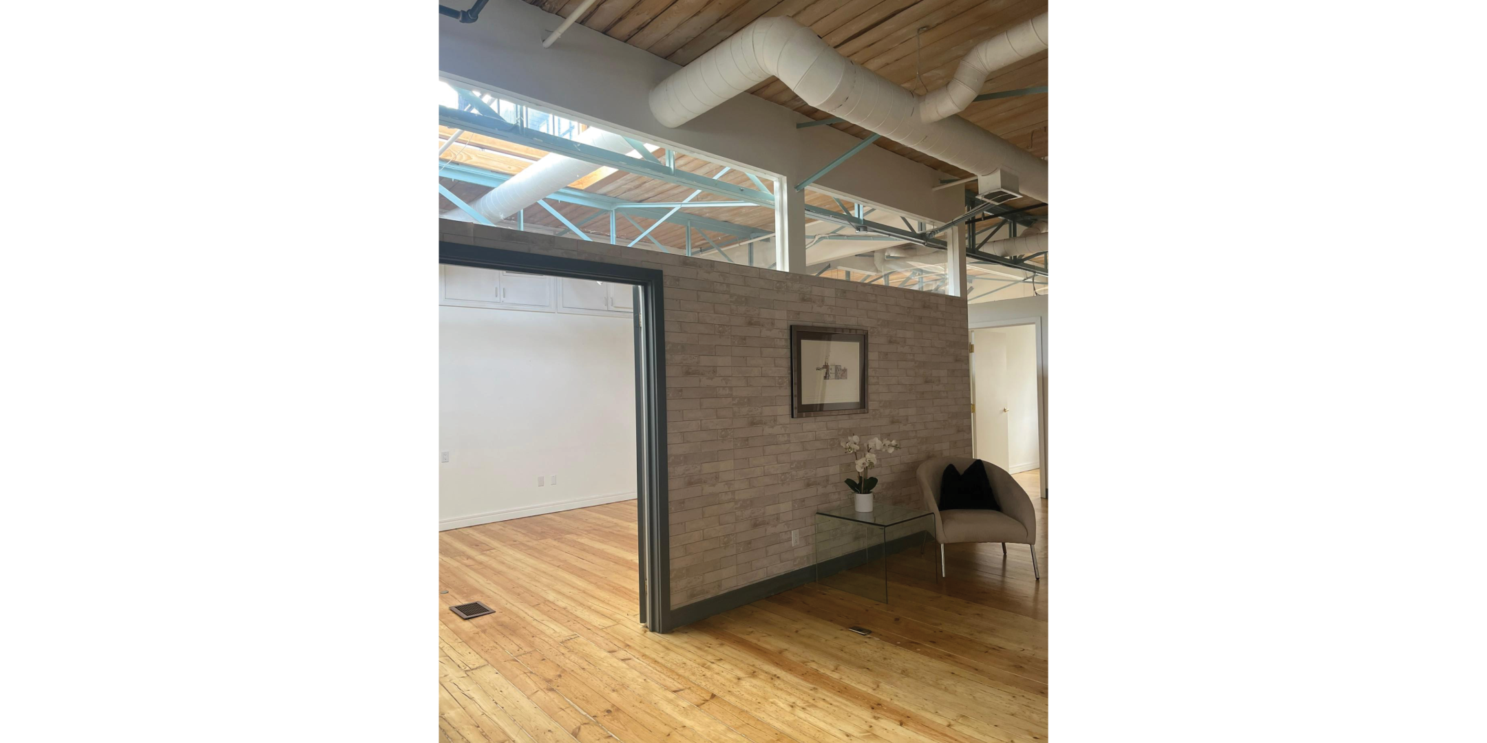 225 Macpherson Avenue showcases a loft office lounge with exposed beams and wood floors.