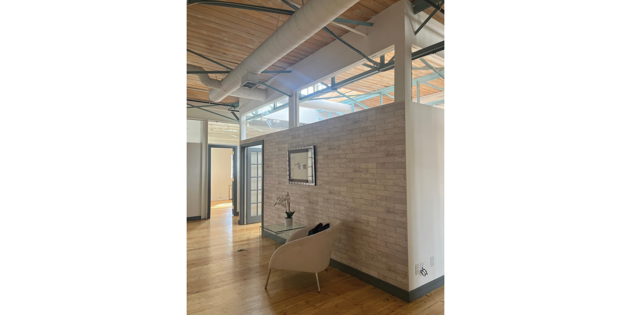 225 Macpherson Avenue features a bright loft office with exposed beams and wood floors.