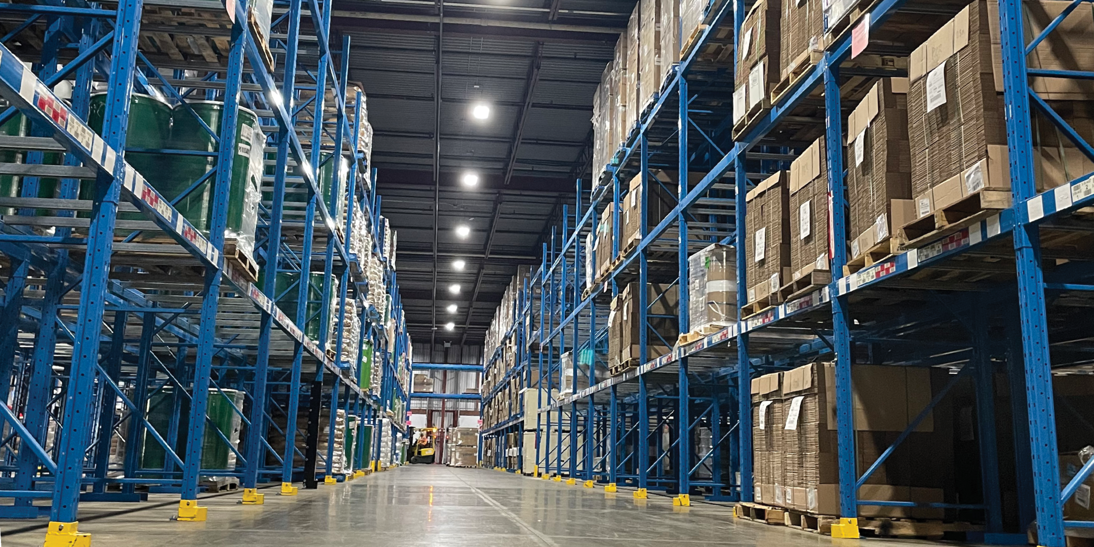 7680 Tranmere Drive Interior of a warehouse with blue pallet racking along a central aisle.