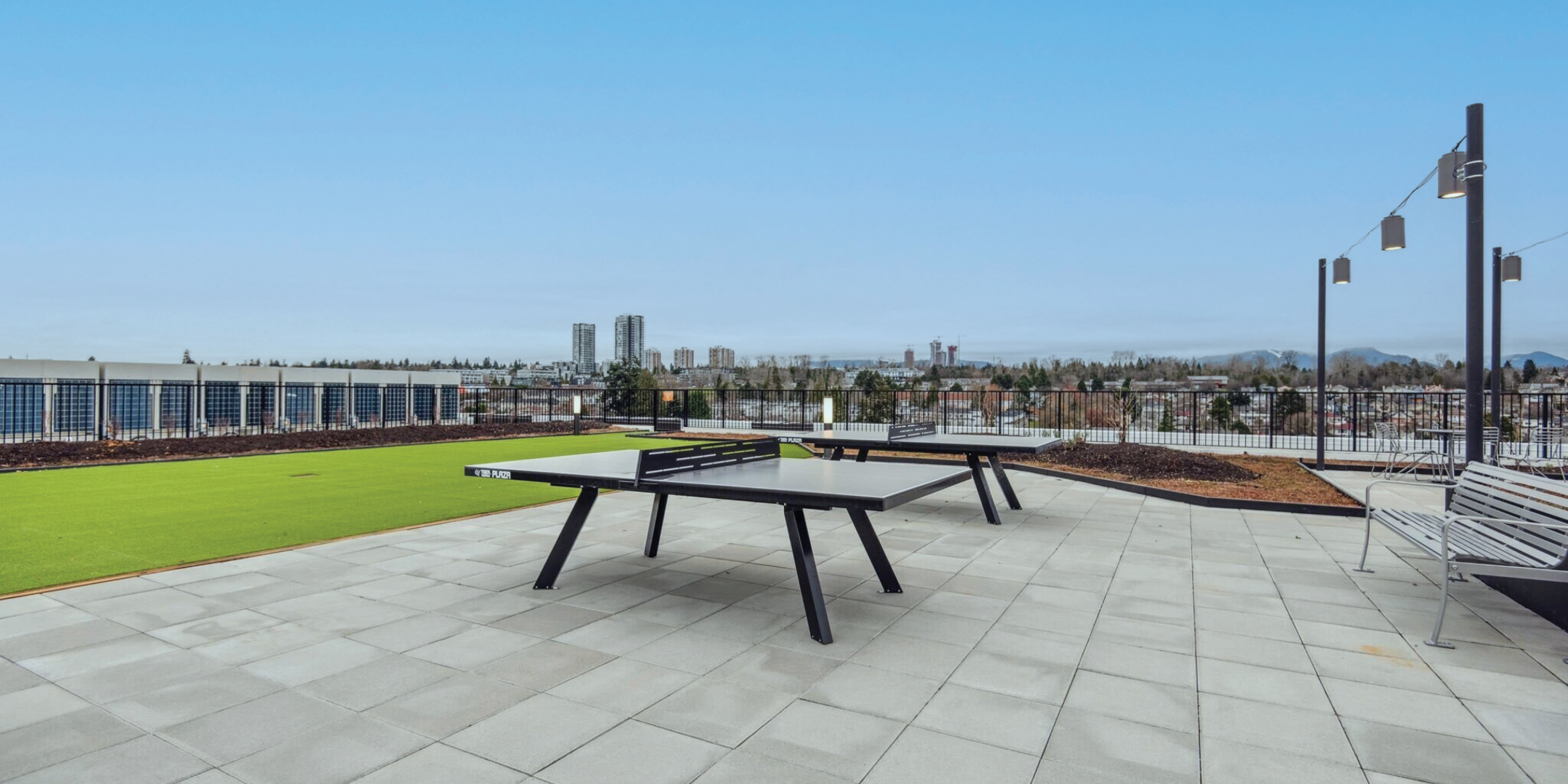 Landscaped rooftop patio with BBQ facicilities, outdoor seating, and a dog run