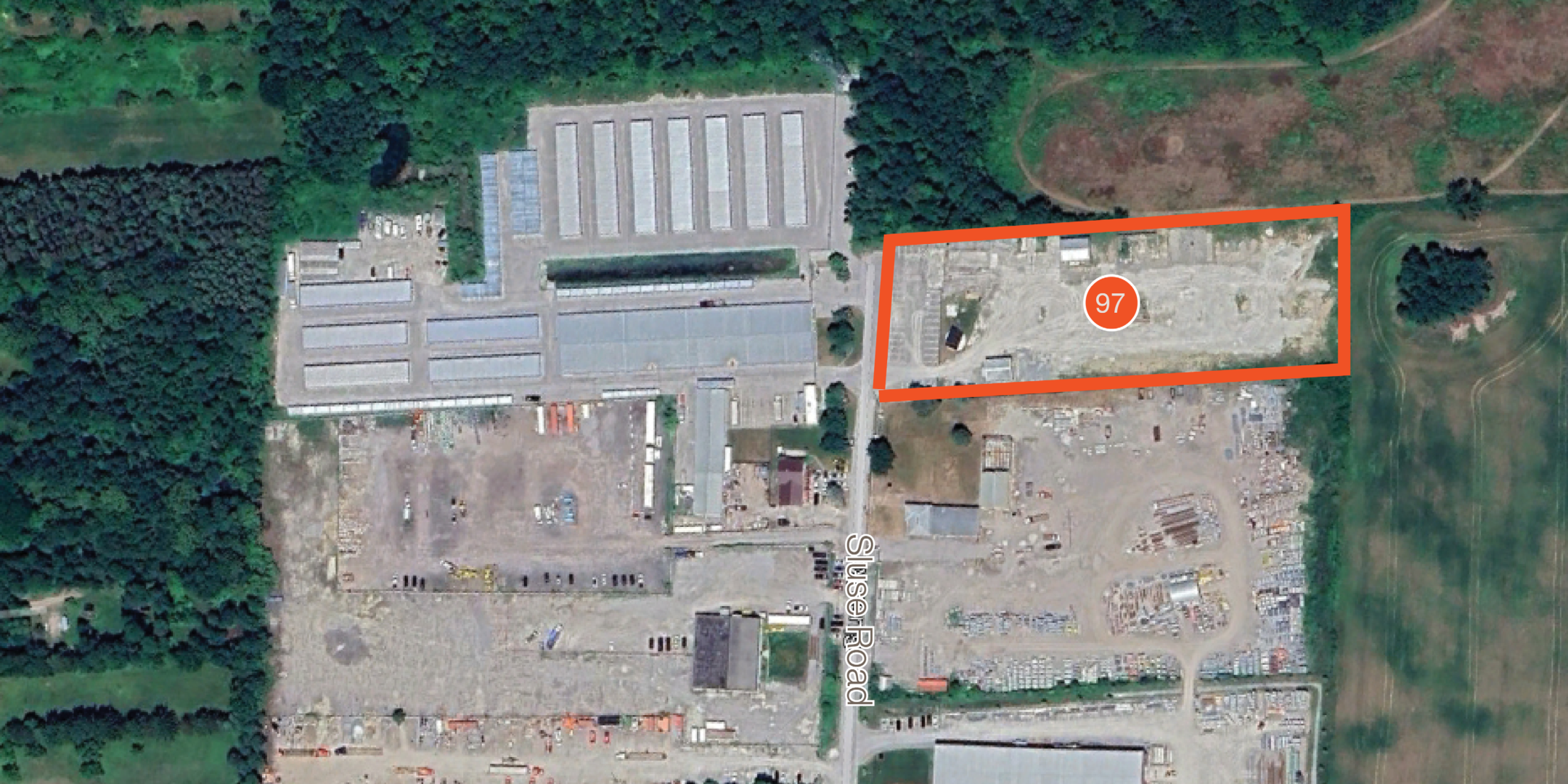 aerial of land site with property boundaries outlined in orange