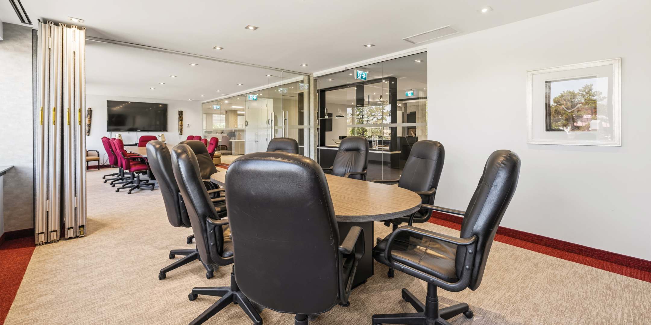 1270 Central Parkway W boardroom with black leather chairs and glass meeting rooms