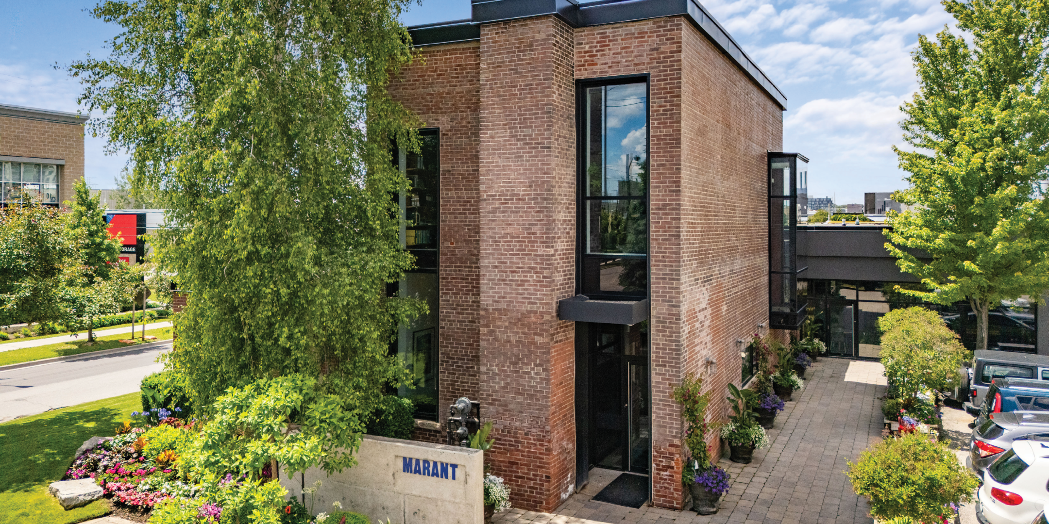 Brown brick office/flex building with trees and landscaping