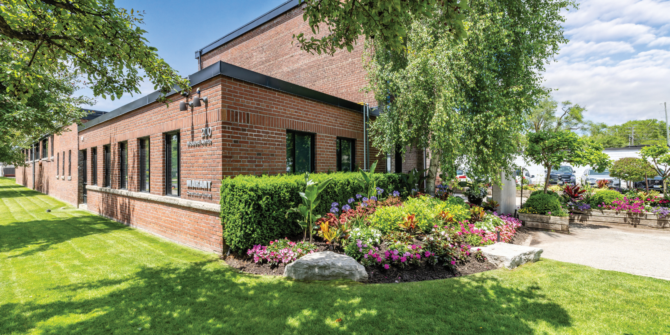 Brown brick office/flex building with trees and landscaping