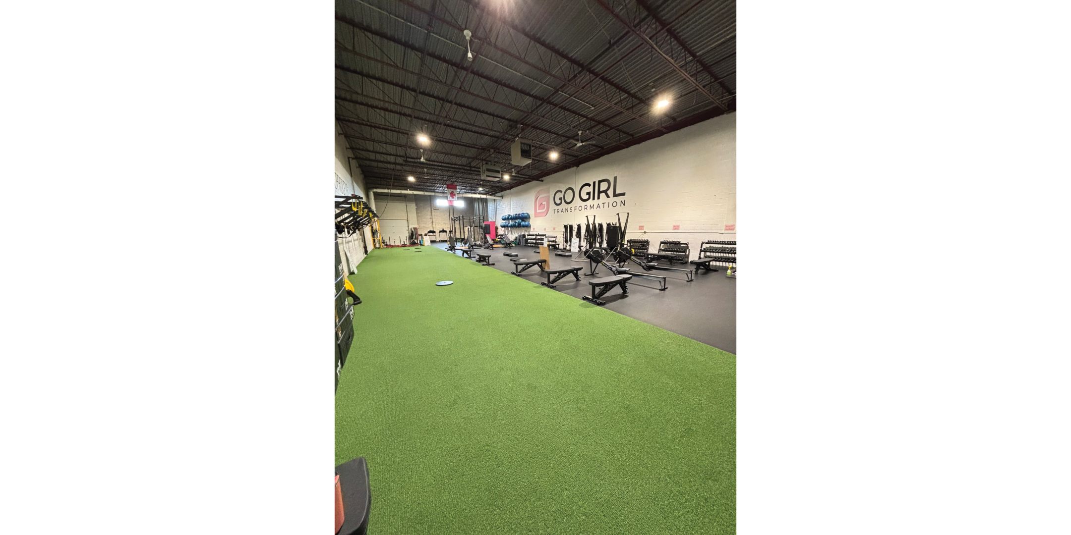 fitness facility with green artificial turf on ground, exposed ceiling and fitness equipment