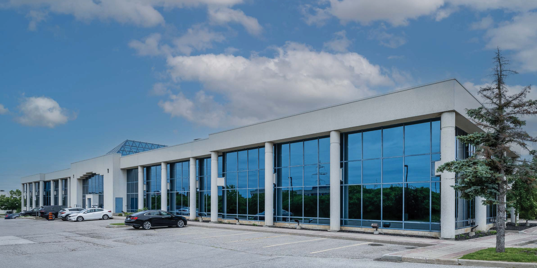 suburban 2 storey office building with grey brick and blue tinted windows