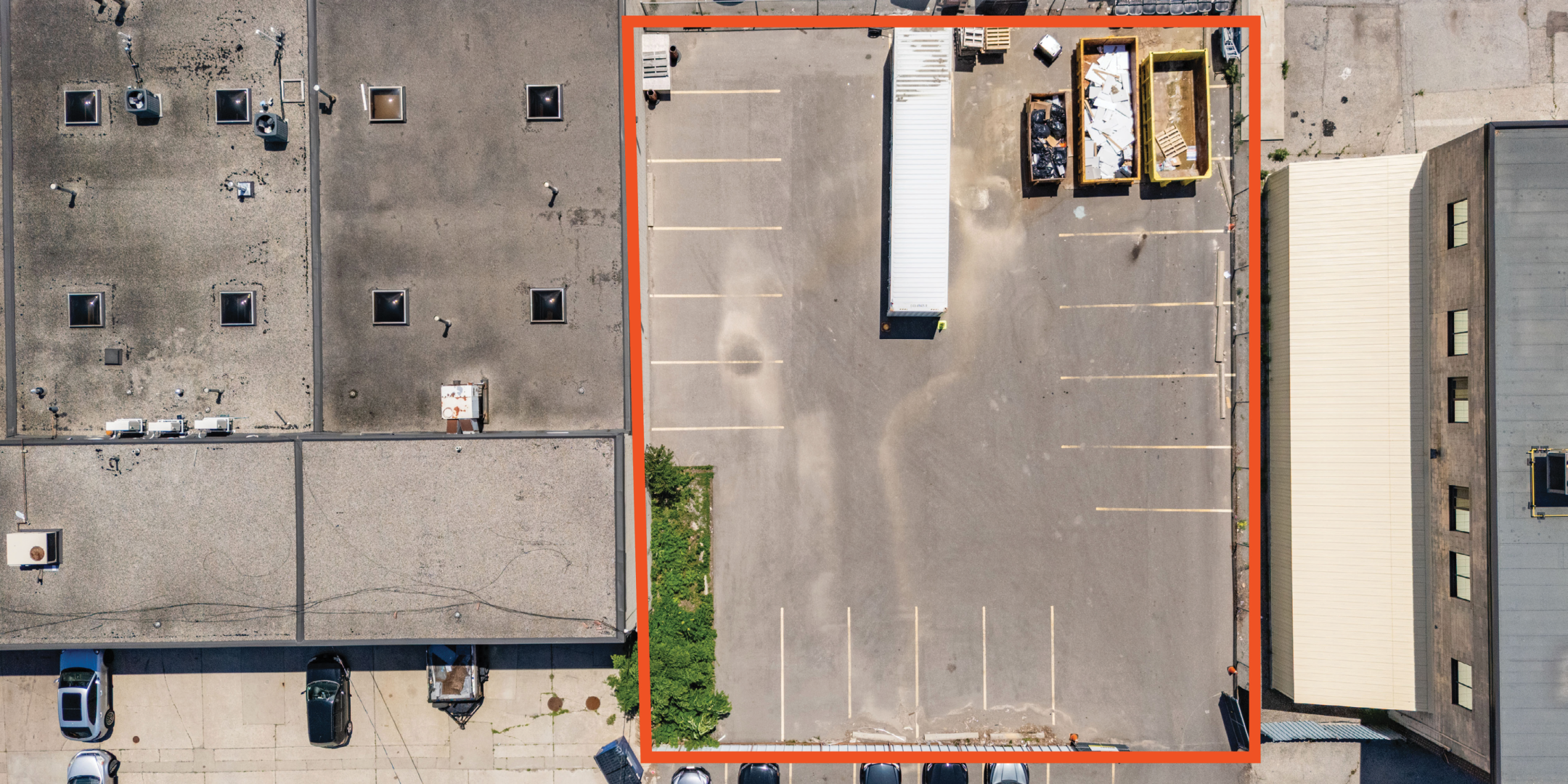 birds eye view of parking lot with property boundaries highlighted in orange