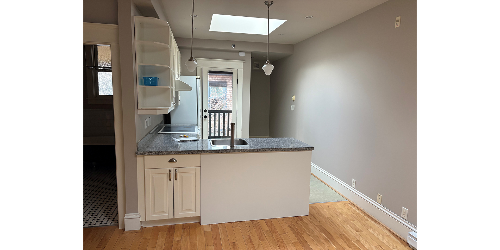 Room with kitchen counter with a separate washroom on the left