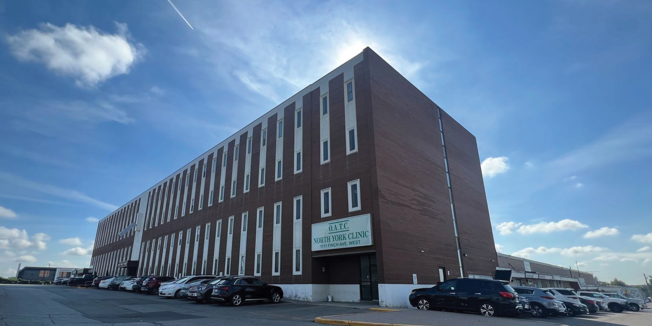 Front of the building surrounded by parked cars