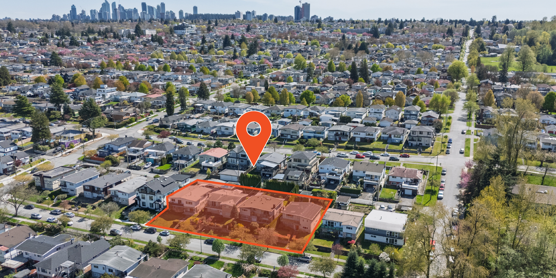 Aerial view of highlighted development site at 3014–3054 East 14th Avenue, marked by and orange boundary and location pin, surrounded by suburban homes, tree-lined streets, and distant city skyline.