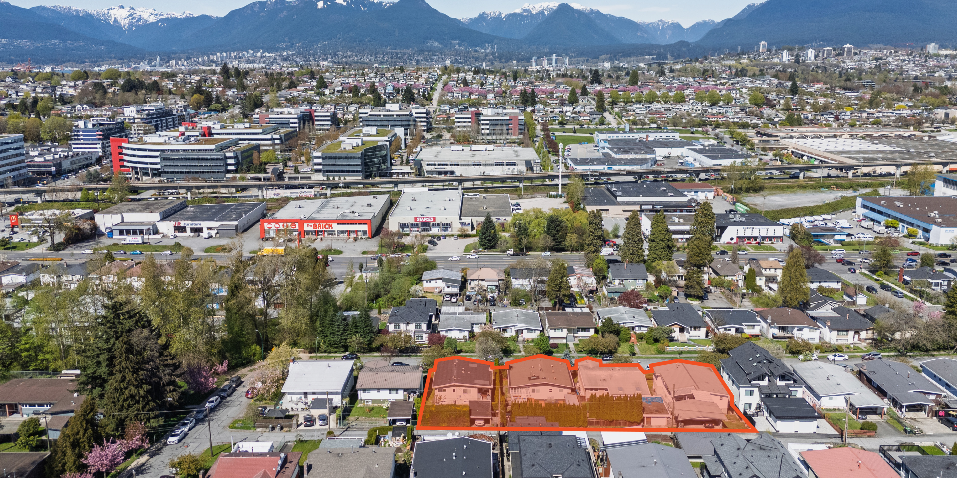 Aerial view of highlighted development site at 3014–3054 East 14th Avenue, marked by and orange boundary, surrounded by suburban homes, tree-lined streets, and distant city skyline.